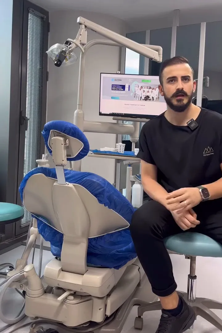 MSc. Dt. Furkan Ozay beside a dental chair in a treatment room