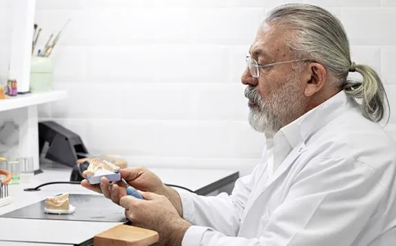 Dental technician checking a model at the lab bench